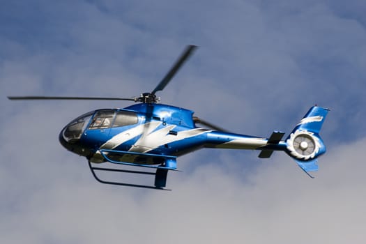 A blue helicopter flying in very low