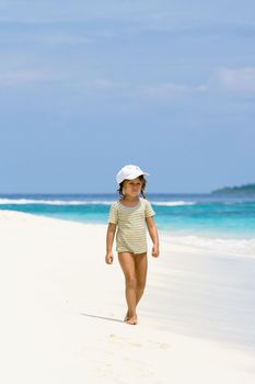 A beautiful young girl walking on the ocean beach in Maldives