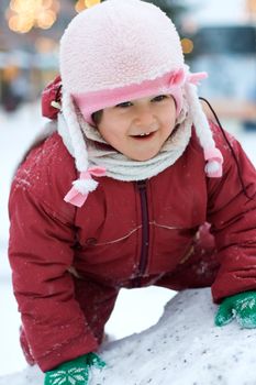 Little happy child on the top of snow hill