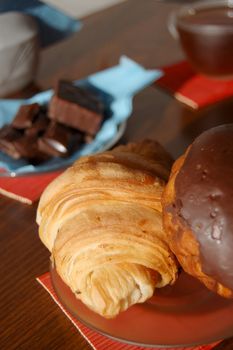 Breakfast with croissant, sweets and a cup of tea