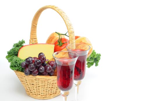 Glasses of red wine with a basket of fresh bread and cheese.