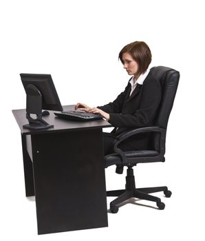 Businesswoman working on a computer at her office desk isolated against a white background.