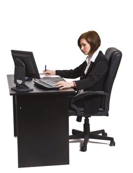 Profile of a businesswoman taking notes at her desk. 