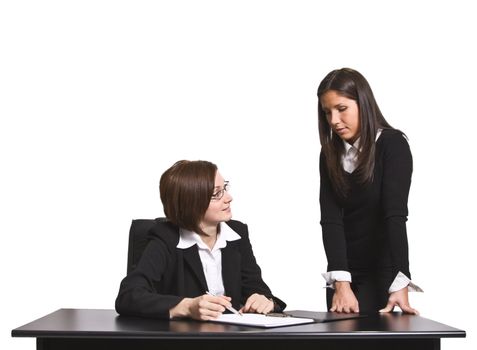 Two businesswomen discussing a file in the office.