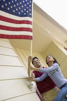 Father and daughter put a US flag on their house