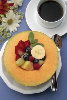 Healthy breakfast  with fresh fruit, coffee and juice on a blue tablecoth