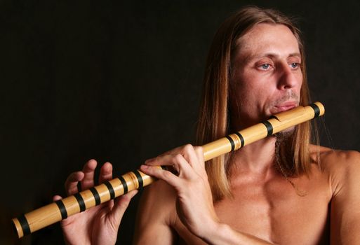 A man playing his wind instrument with expression