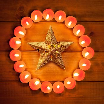 christmas candles circle over wood and golden star symbol