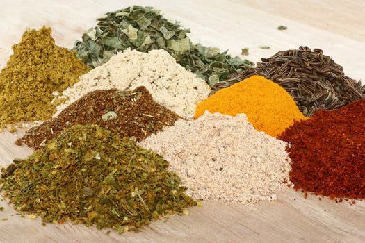 A set of spices on wooden cutting board.
