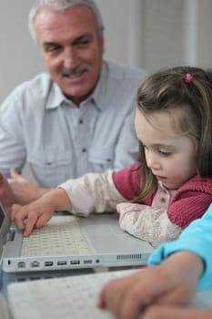 Child on a laptop with her grandfather