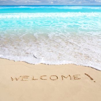 greetings welcome beach spell written on sand Caribbean tropical sea