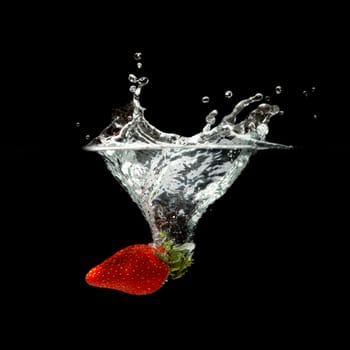 strawberry splashing in water over black background