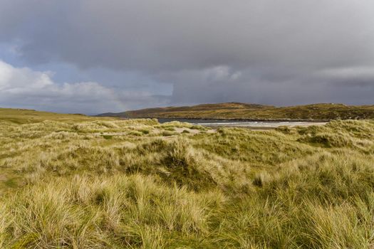 dunes in north scotland with grass and hills in the background