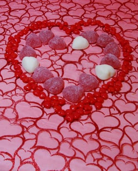 A background of material with hearts and cinnamon candies