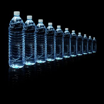Several bottles of drinking water isolated on a black background