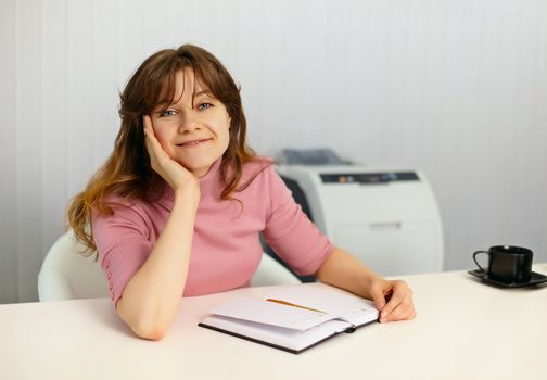 Smiling girl in the office of the table