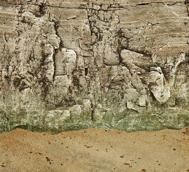 The granite rock on a sandy beach - background