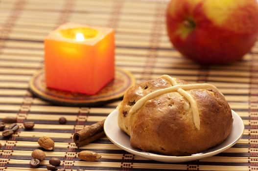 Cross bun with raisins and dried apricots, romantic still life