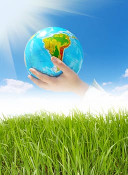 globe in hands under blue sky