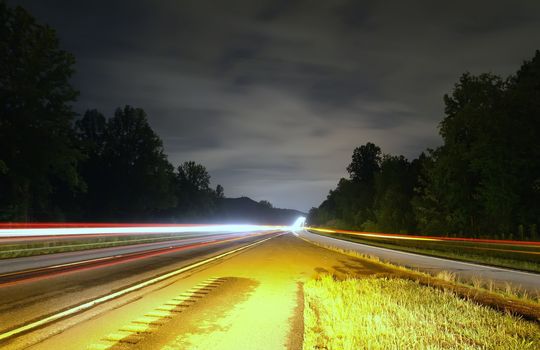 highway traffic at night between the exit ramp