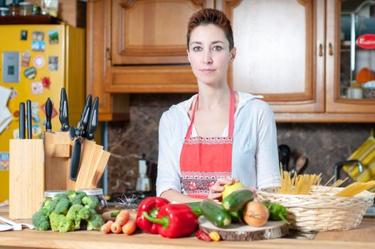 beautiful housewife cooking vegetables in the kitchen