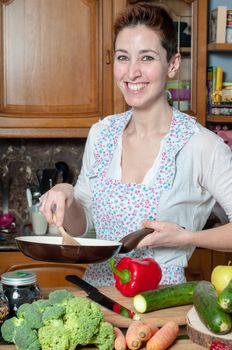 beautiful housewife cooking vegetables in the kitchen