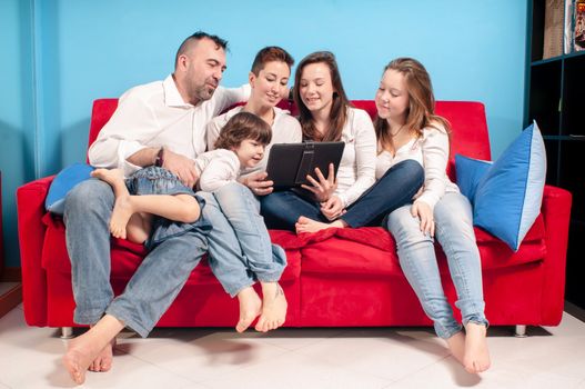 happy family on the couch using tablet in the living room