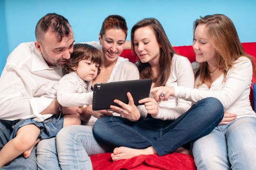 happy family on the couch using tablet in the living room