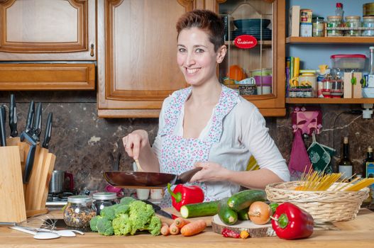 beautiful housewife cooking vegetables in the kitchen