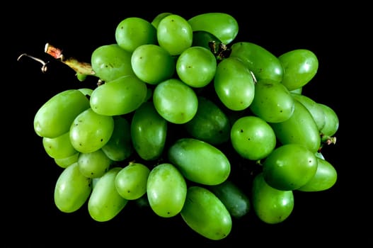 bunch of green grapes on a black background