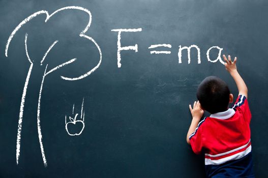 Young boy drawing F=ma on the wall