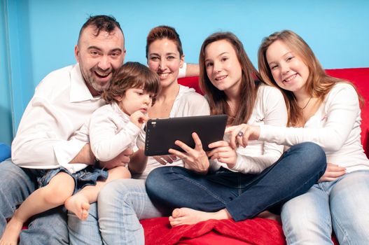 happy family on the couch using tablet in the living room