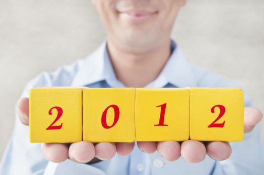 Salesman holding building blocks, building blocks that read 2012, Representatives for the 2012 years