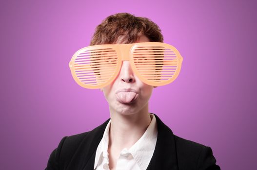 businesswoman with big funny eyeglasses and tongue out on pink background