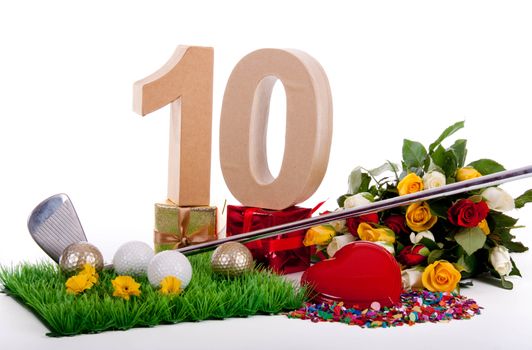 Roses, a golf club and golf balls on an artificial peace of grass to be used as a birthday card