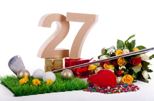 Roses, a golf club and golf balls on an artificial peace of grass to be used as a birthday card