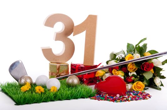 Roses, a golf club and golf balls on an artificial peace of grass to be used as a birthday card