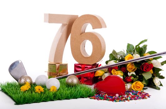 Roses, a golf club and golf balls on an artificial peace of grass to be used as a birthday card