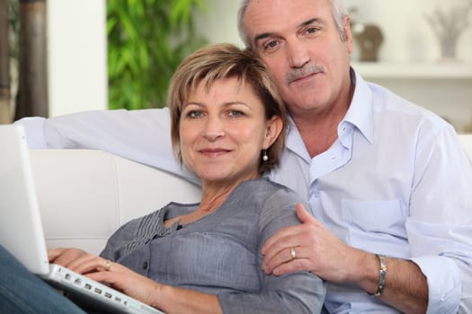 Couple using a laptop at home