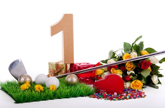 Roses, a golf club and golf balls on an artificial peace of grass to be used as a birthday card