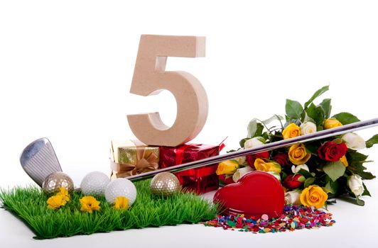 Roses, a golf club and golf balls on an artificial peace of grass to be used as a birthday card