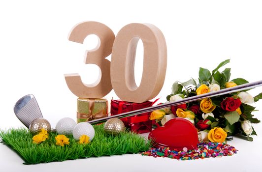 Roses, a golf club and golf balls on an artificial peace of grass to be used as a birthday card