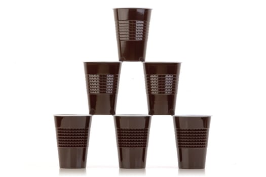 Stack of brown plastic cups arranged on white.