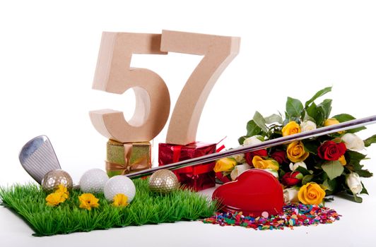 Roses, a golf club and golf balls on an artificial peace of grass to be used as a birthday card