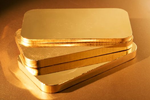 three gold ingots on a golden background. shallow depth of field.