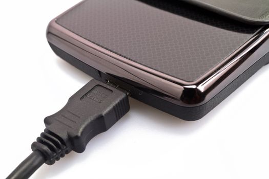 close up view of a portable harddisk in  soft leather case and USB cable on white background