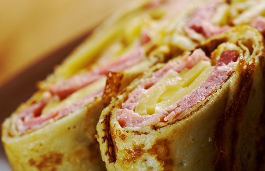 rolled pancakes stuffed ham and cheese. Shallow depth-of-field.