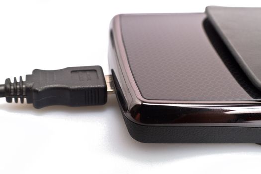 close up view of a portable harddisk in  soft leather case and USB cable on white background