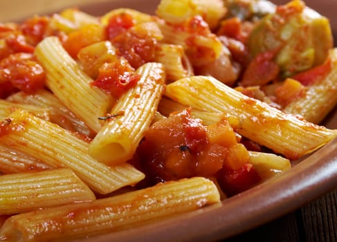 Italian Penne rigate pasta  with  vegetable  tomato sauce  on wooden table