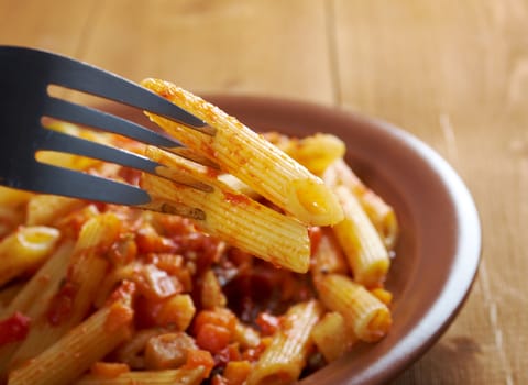 Italian Penne rigate pasta  with  vegetable  tomato sauce  on wooden table